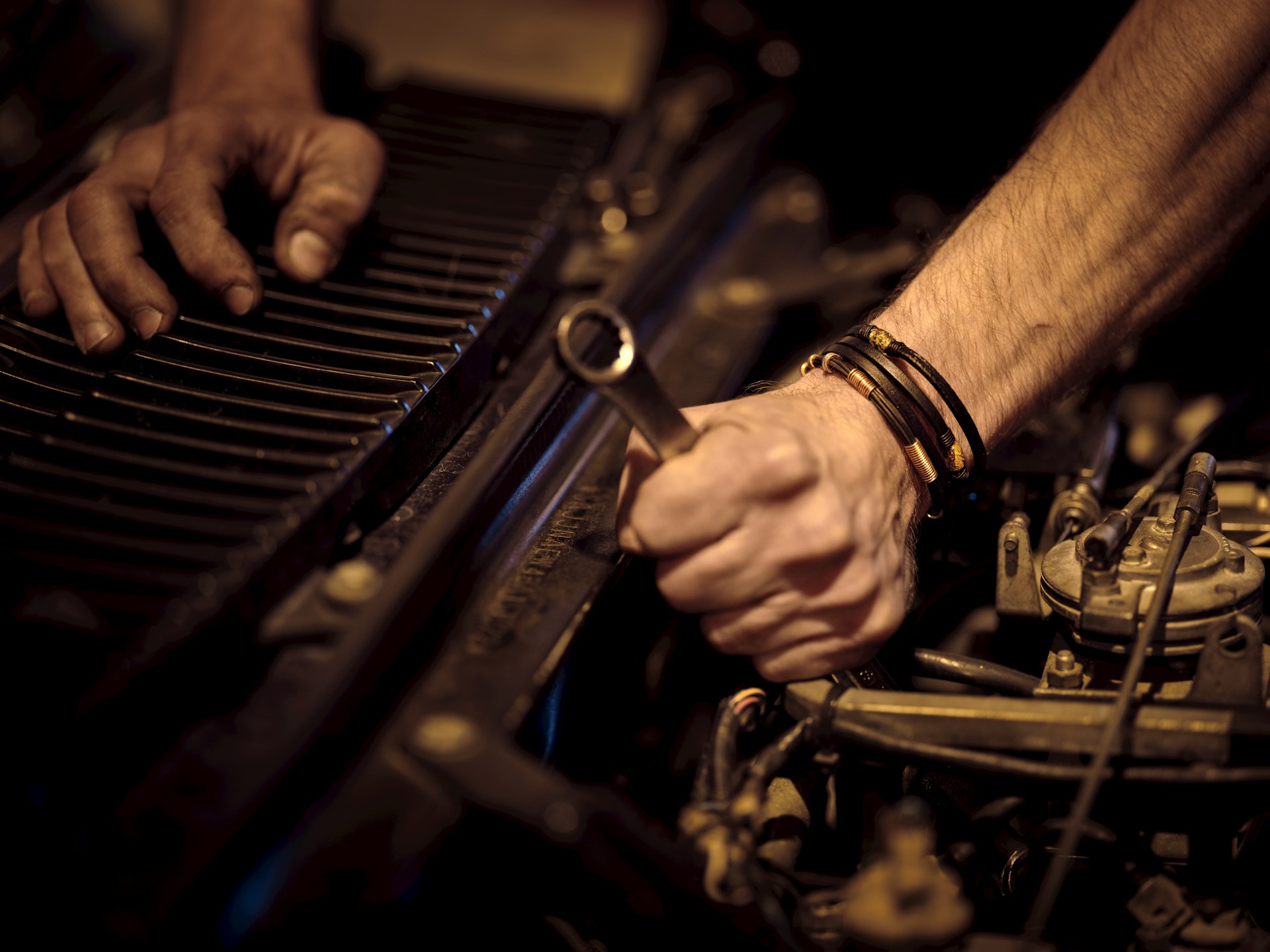 photo of two hands fixing an engine
